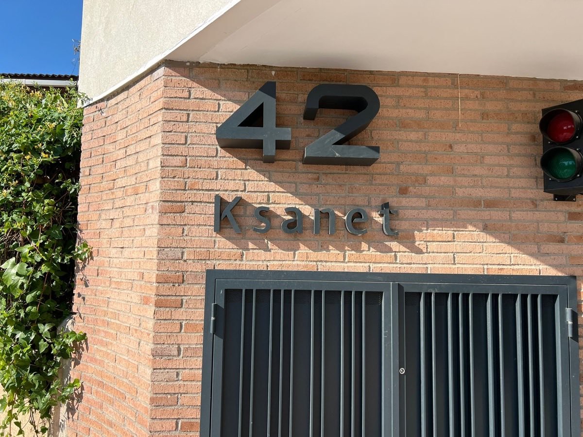 Número 42 y rótulo Ksanet sobre el zócalo de ladrillo del portal del Residencial Moncayo.